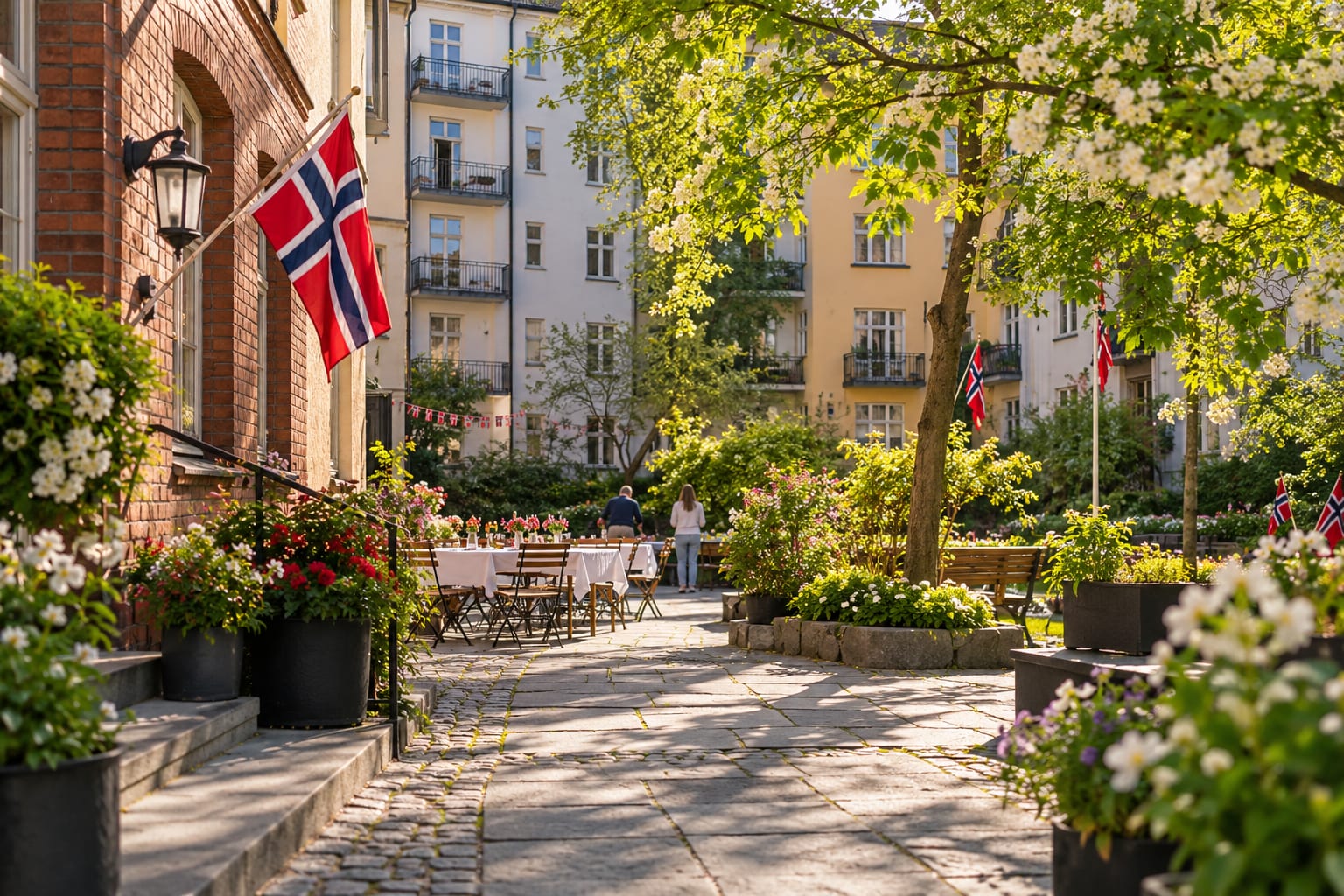 Bakgård mellom bygårder pyntet med flagg og dekket bord til 17. mai
